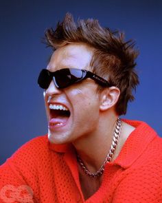 a young man with sunglasses on his face and mouth open, making a silly face