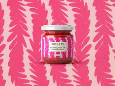 a jar of kello on a pink and white background with palm fronds