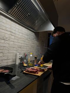 a man standing in front of a stove preparing food on top of a wooden cutting board