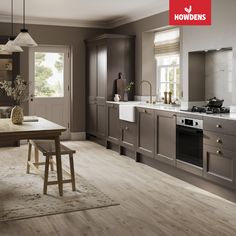 an image of a modern kitchen setting with wood flooring and grey cabinets in the background