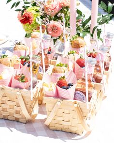 baskets filled with strawberries and pastries on top of a table next to flowers