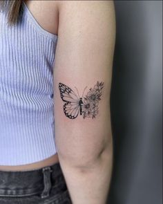 a woman's arm with a butterfly and flowers tattoo on the left side of her arm