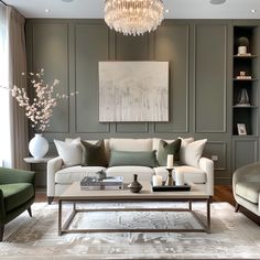 a living room filled with furniture and a chandelier hanging above the couches