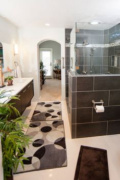 a bathroom with black and white tile on the floor, shower stall and toilet area