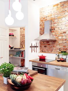 a bowl of fruit sitting on top of a wooden counter next to a stove and oven