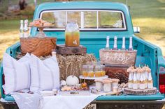 an old blue truck is filled with food and drinks