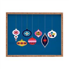 a wooden frame with ornaments hanging from it's sides on a blue wall,