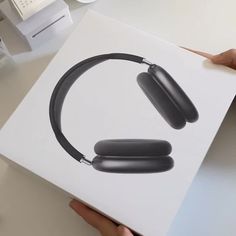 a pair of black headphones sitting on top of a white box