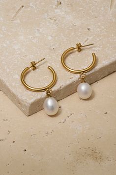 Gorgeous gold hoop featuring a pearl accent. Classic Gold Hoop Pearl Earrings, Classic Gold Hoop Earrings With Pearl Charm, Classic Gold Hoop Earrings With Pearl Drop, Classic Gold Hoop Earrings With Pearl Chain, Classic Small Hoop Gold Pearl Earrings, Hoop Earrings With Pearl Pendant, Yellow Gold Metal Pearl Earrings, Formal Hoop Earrings With Pearl Charm, Elegant Matte Gold Small Hoop Jewelry