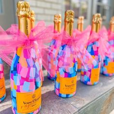 several bottles of champagne are lined up on a table with pink and blue squares around them