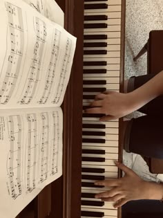 two hands are playing the piano with sheet music