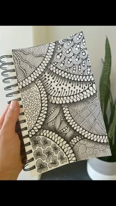 someone is holding up a notebook with an intricate design on it