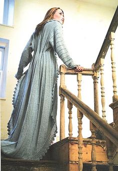 a woman in a long dress is standing on the stairs