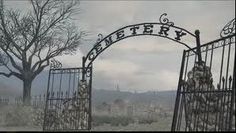 an iron gate with the word cemetery written on it in front of a barren tree