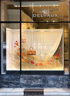 a store front window with an assortment of handbags in it