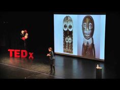 two children are standing on stage in front of large screens with images of people's faces