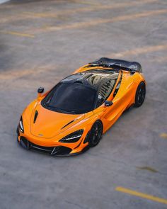 an orange sports car is parked in the parking lot