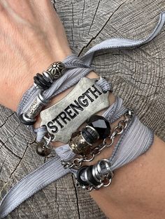 'Strength' - "You were given this life because you were Strong enough to live it"  These bracelets are meant to inspire and empower the wearer!  You can overcome anything!   Silk ribbon with silver chains and glass and crystal bead accents, metal 'STRENGTH' curved tag. Choose your color from the options shown!   Check out more Silk Ribbon Wrap Bracelets here: https://www.etsy.com/shop/gennextjewelry?section_id=18514502&ref=shopsection_leftnav_6 Sizing: All Bracelets are made to fit 7-8" wrists.  If you need something smaller or larger, please mention the length needed when checking out.  I can of course make custom fits.   Guarantee: All my designs are handcrafted with FUN in mind! I love creating pieces thinking about a Fearless Female getting ready to go to a Club, or a Boho Chic Chick r