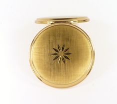 a gold pocket watch with a star on the front and center piece in the middle