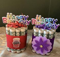 two jars filled with candles on top of a table covered in paper and decorations that say happy birthday