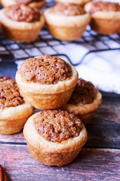 several small muffins sitting on top of a cooling rack next to pecans