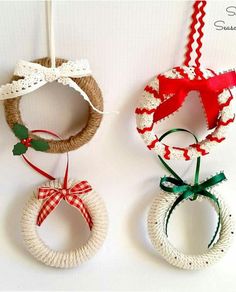 three christmas wreaths hanging from twine with ribbons and bows attached to each other