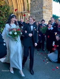 a bride and groom walk down the aisle as confetti is thrown around them