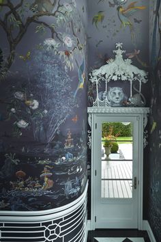 a room with a wallpapered mural on the walls and door to another room