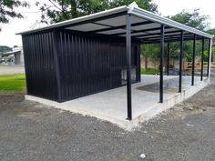 a black metal structure sitting on the side of a road