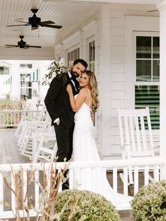 a bride and groom pose on the porch of their home