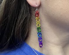 a woman wearing rainbow colored earrings on her ear