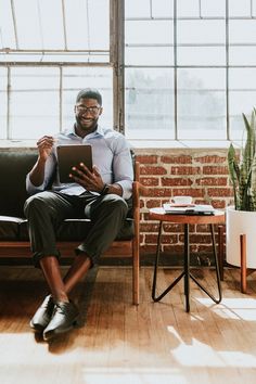 a man sitting in a chair holding a tablet