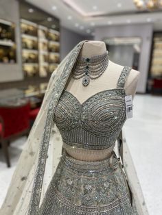 Make your wedding day extra special with the beautiful Bridal Lehenga BL-028! This stunning lehenga features intricate embroidery and luxurious fabrics that will make any bride shine on her big day. Elevate your bridal look with this gorgeous piece! Fabric: Net with satin lining WASH CARE INSTRUCTIONS - Please Dry clean only when it is applicable Ready to Ship! Bollywood Style Designer Wedding Dress With Intricate Embroidery, Silver Traditional Wear With Intricate Embroidery For Designer Wear, Silver Choli With Intricate Embroidery In Traditional Drape, Silver Choli With Intricate Embroidery, Wedding Anarkali Set With Stone Work, Silver Bollywood Gown With Intricate Embroidery, Bollywood Style Silver Gown With Intricate Embroidery, Traditional Draped Dupatta With Stone Work For Wedding, Designer Semi-stitched Gown With Stone Work