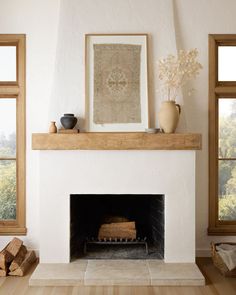 a fireplace in a living room filled with furniture and art on top of the mantle