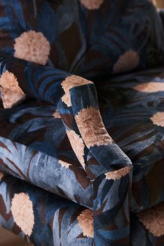 an upholstered chair with blue and brown floral fabric