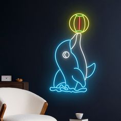 a neon dolphin with a ball in it's mouth sitting on the floor next to a chair