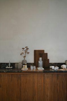 the kitchen counter is covered with dishes and cups, along with a vase filled with flowers