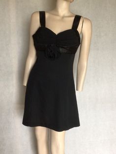 "Vtg Black 80s does 50s LBD flared mini cocktail formal party dress 8/10 Preowned condition. 10/10 No issues to note. No rips, tears, stains or strange odours. Info A Sydney Design label. Based in the eastern suburbs of Sydney.  Style 80s does 50s LBD. A jet black, 100% polyester flared mini dress. Wide shoulder straps Ruched bodice accentuated with a wide black satin ribbon and a black fabric rose.   The bodice is reinforced. The rest of the dress is unlined. Fastens with centre back long zip. The skirt is A line in shape. Not full but still moves nicely around the legs. Label Burcul Size label. M Can be gently hand washed. Best fit Aus 10 Go by measurements below dress laid flat Underarm to underarm. 17\". 43cm Waist. 15\". 38cm Hips. 19\". 48cm Length. 33\". 84cm My photos form an impor Fitted A-line Mini Dress For Holiday, Formal Mini Dress With Fitted Bodice, Holiday Cocktail Mini Dress With Sweetheart Neckline, Formal Mini Dress With Sweetheart Neckline For Evening, Fitted Mini Dress With Sweetheart Neckline For Formal Occasions, Formal Evening Mini Dress Fitted, Lined Mini Dress For Prom, Formal Evening Fitted Mini Dress, Formal A-line Mini Dress With Lined Bodice