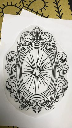 a paper with a drawing of a clock on it's side and some other things in the background