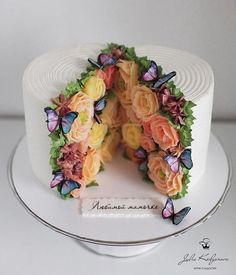 there is a cake decorated with flowers and butterflies on the top, as if it were cut in half