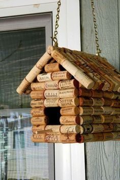 a birdhouse made out of wine corks is hanging on the front door window