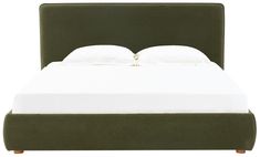 a bed with white sheets and green headboard