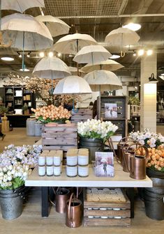 an open market with flowers, candles and umbrellas hanging from the ceiling above it