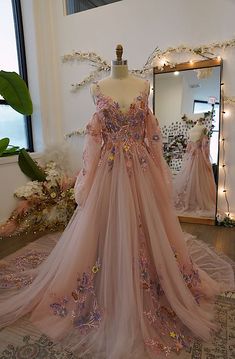 a dress on display in front of a mirror with lights around it and flowers all over the floor