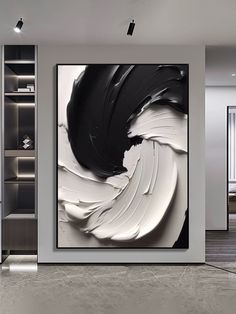 an abstract black and white painting hangs on the wall