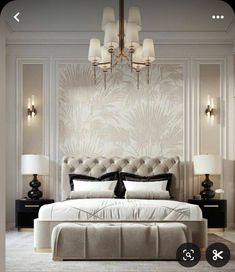 a large bed sitting under a chandelier in a bedroom next to two lamps