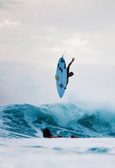 a man riding a surfboard on top of a wave in the ocean