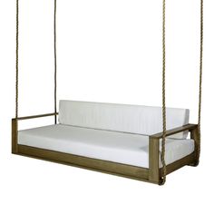 a wooden swing bed with white sheets on it's back and seat cushiones