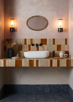 a bathroom with a sink, mirror and two lights on the side of the wall