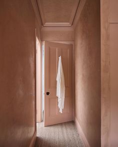 an open door with a towel hanging from it's side in a hallway between two walls